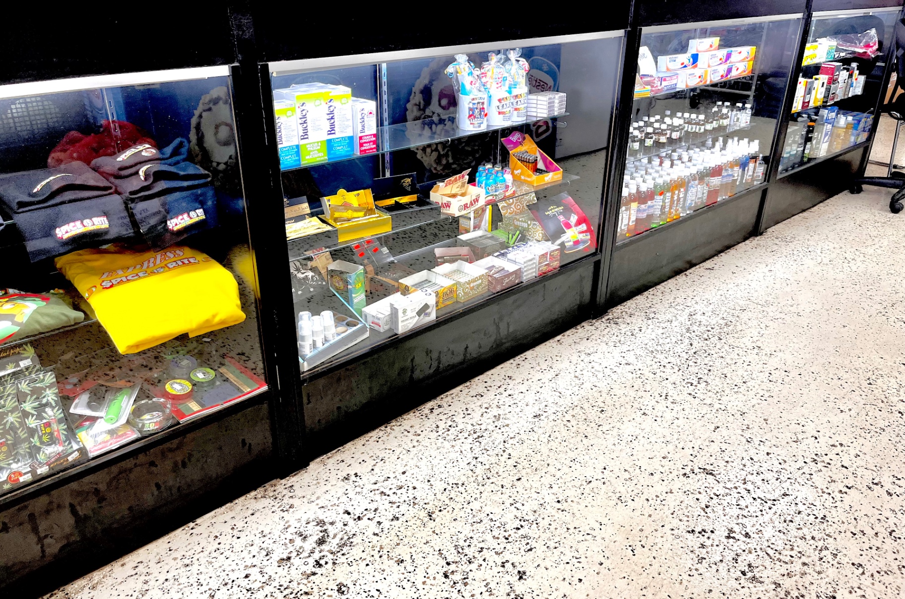 Front counter display case with Spice Is Rite t-shirts, remedies and convenience items