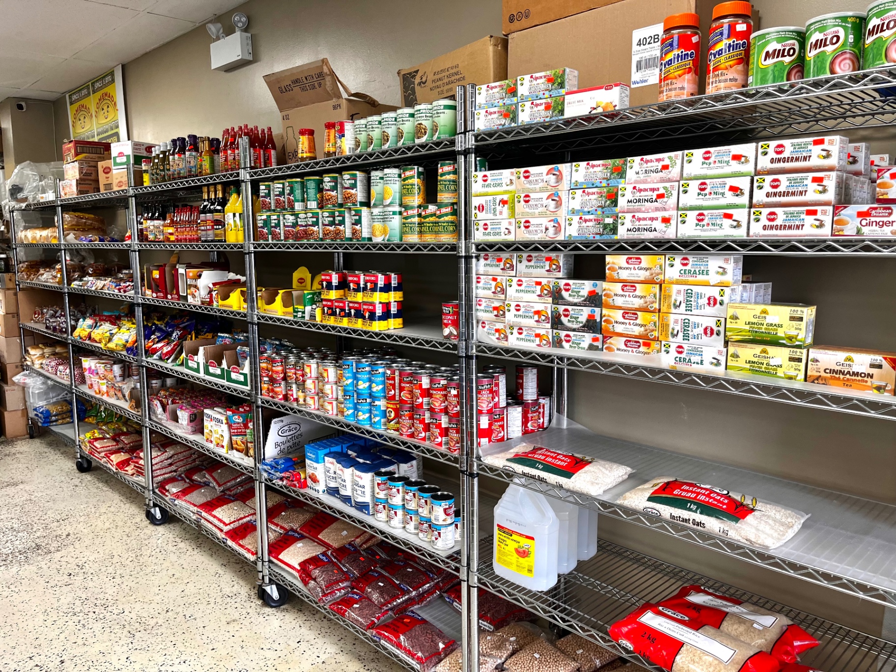Shelves stocked with Caribbean groceries, canned goods, teas and rice