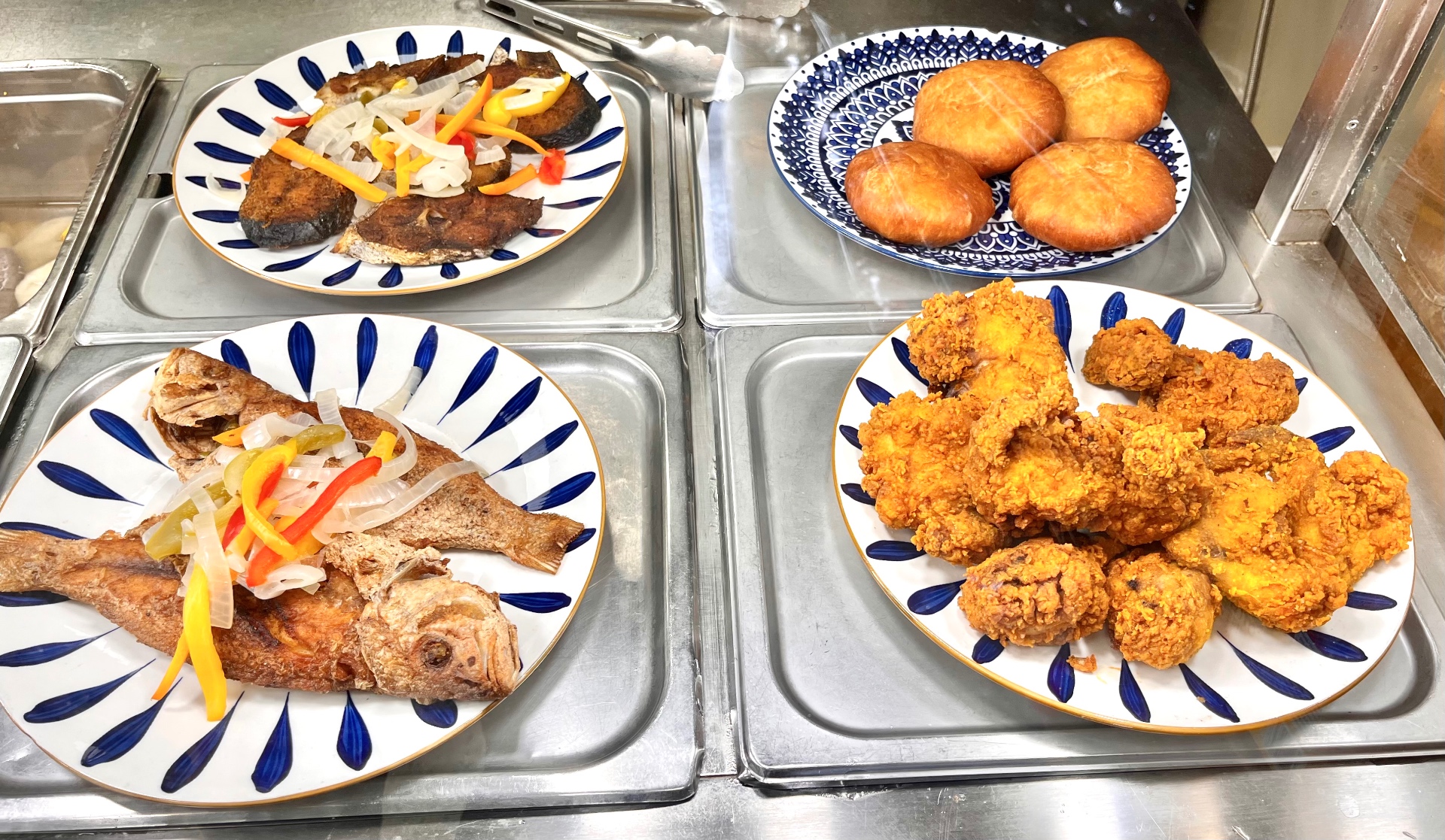 Fried snapper, king fish, festival dumplings and fried chicken on serving plates